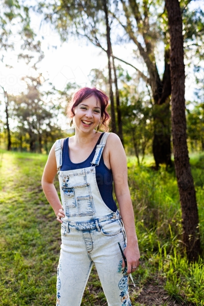 Portrait of young artist hobbyist in sunlight outside holding brushes - Australian Stock Image