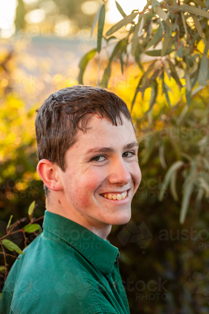 Portrait of young Aussie bloke in green with gum leaves in background - Australian Stock Image