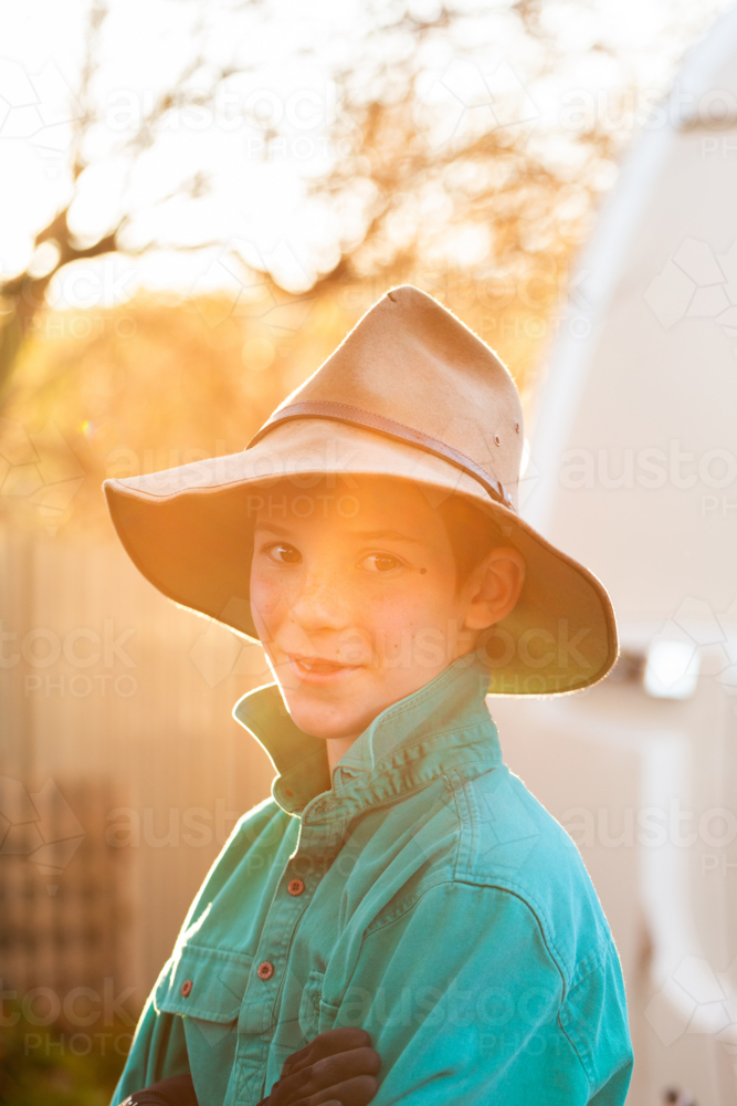 Portrait of young Australian boy in backyard with akubra hat on - Australian Stock Image