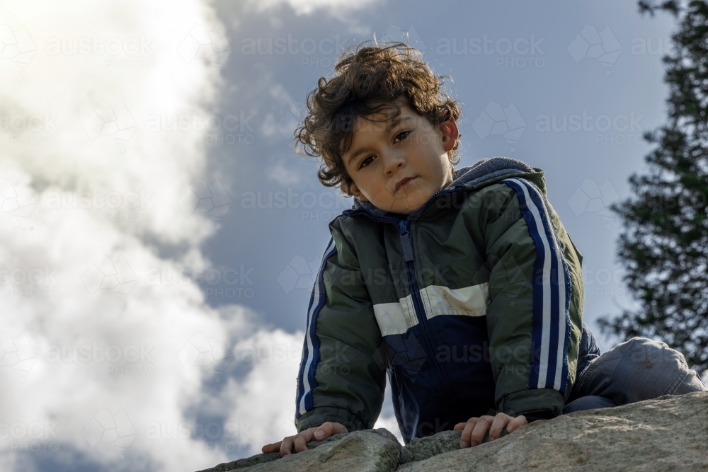 Portrait of young boy after climbing rock - Australian Stock Image