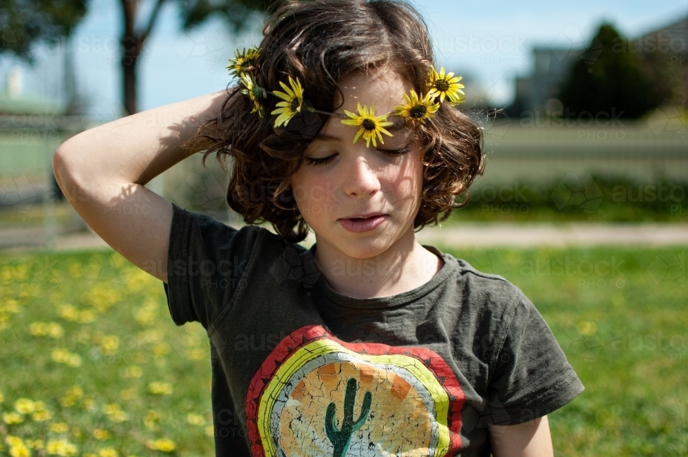 Portrait of young child wearing a daisy chain made of capeweed - Australian Stock Image