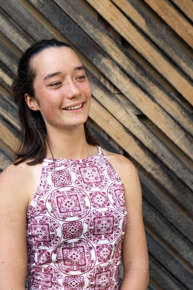 Portrait of young female outdoors with textured wooden background - Australian Stock Image