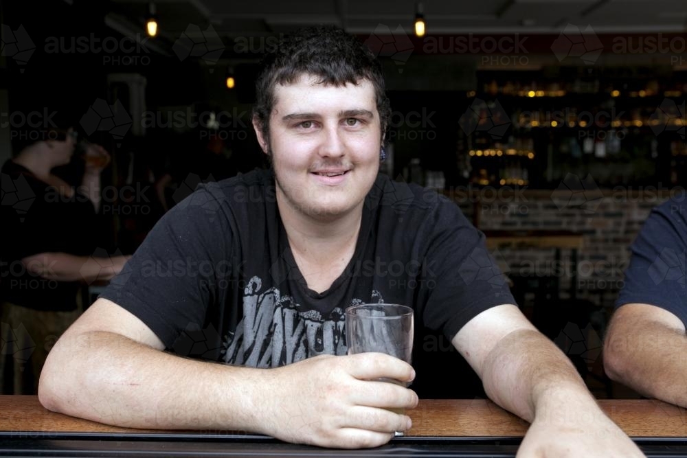 Portrait of young man having a drink at pub - Australian Stock Image
