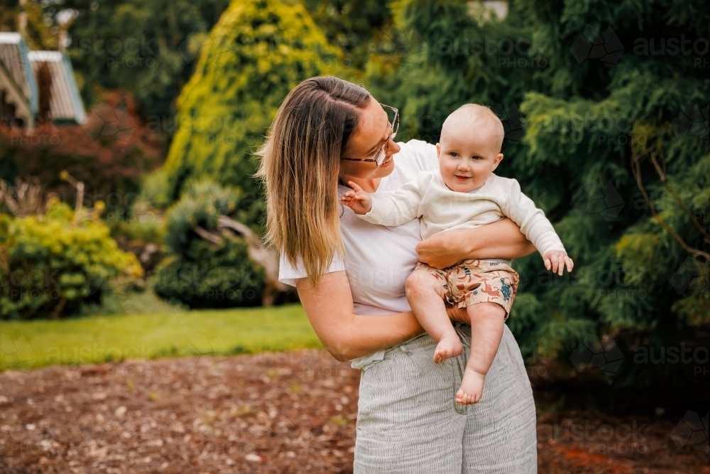 Portrait of young mum and small baby together in the park - Australian Stock Image