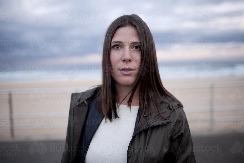 Portrait of young woman at the beach in winter - Australian Stock Image