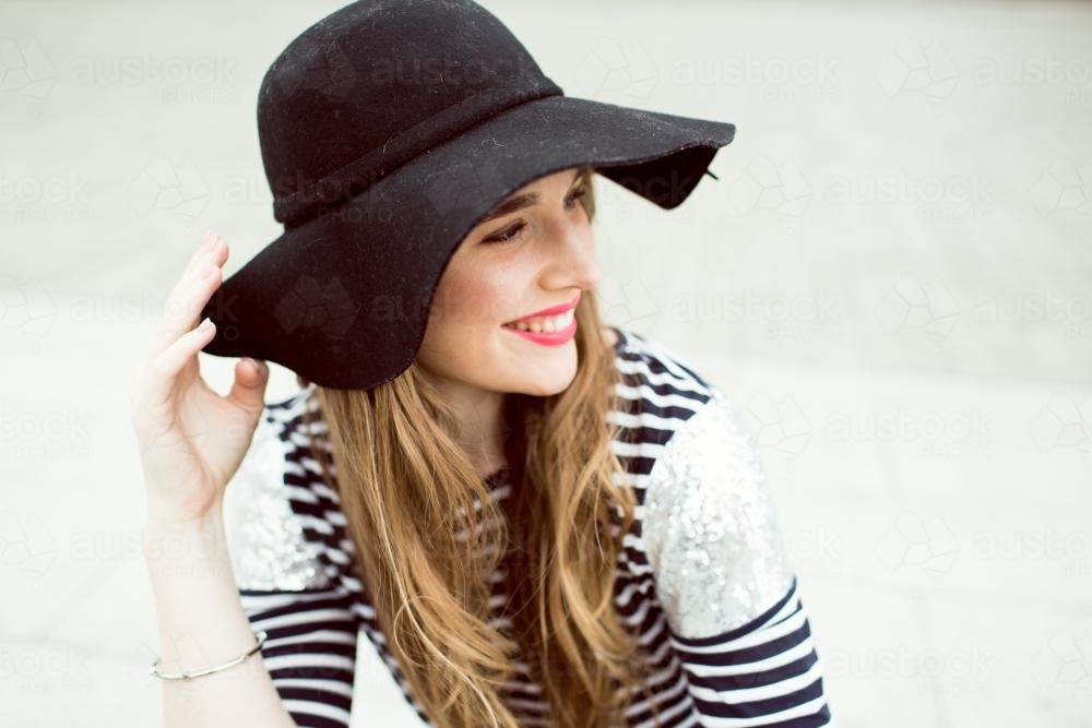 Portrait of young woman wearing a hat and looking over shoulder - Australian Stock Image