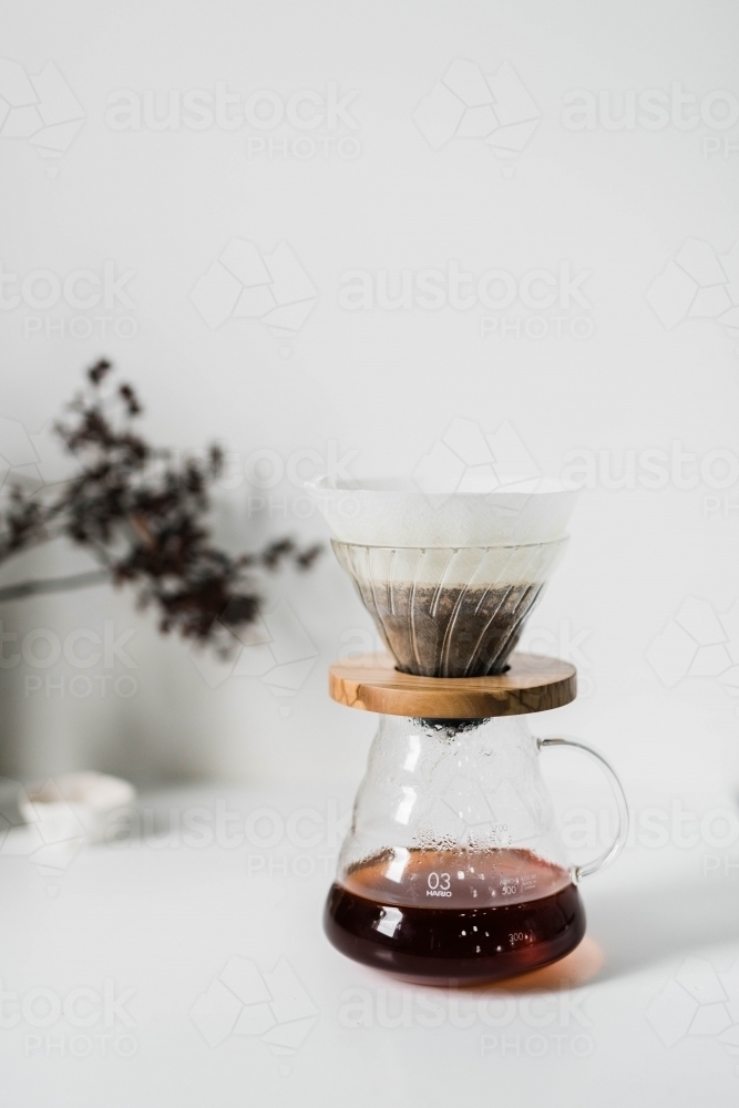 Pour over coffee brewing on white kitchen bench - Australian Stock Image