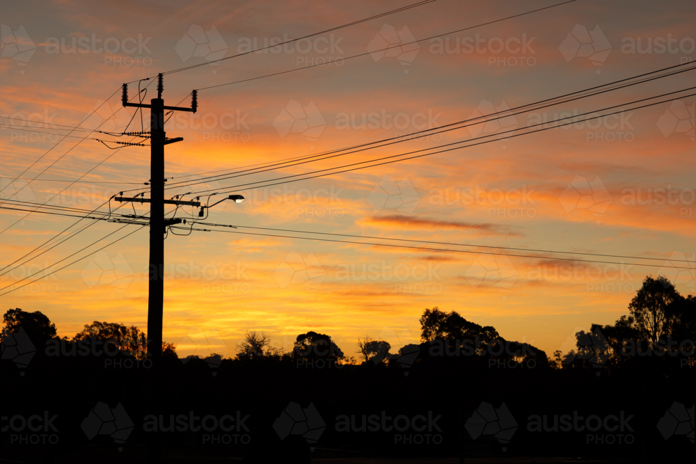 power lines criss-crossing the sky at sunset - Australian Stock Image