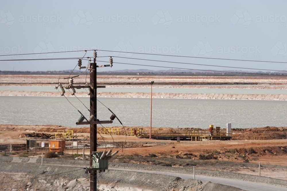 Power pole with industrial site in background - Australian Stock Image