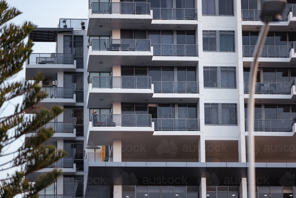 Pre-teen boy standing on balcony of high rise apartment building on the Gold Coast - Australian Stock Image
