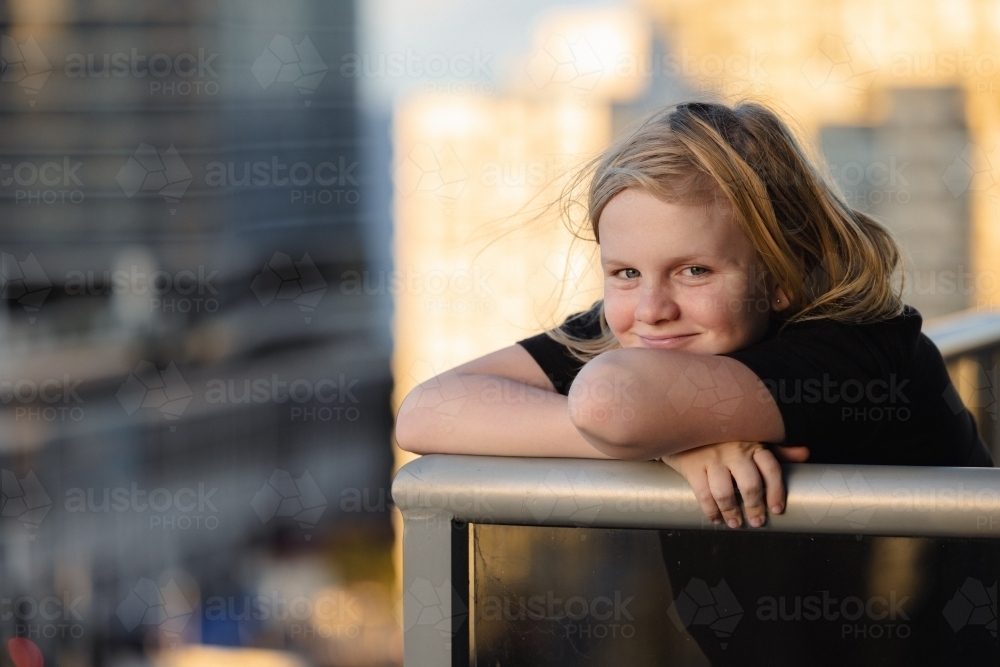 Pre-teen boy standing on balcony of high rise building on the Gold Coast with view of Surfers Paradi - Australian Stock Image