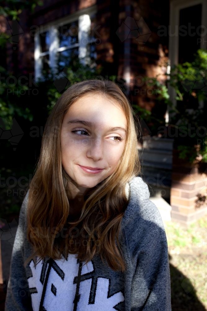 Pre teen girl smiling in the dappled sunlight - Australian Stock Image