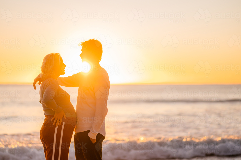 Pregnant couple enjoying sunrise at Manly Beach - Australian Stock Image