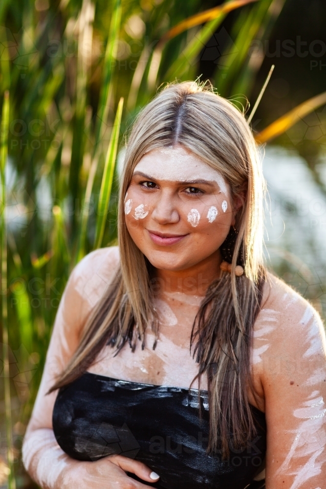 Pregnant woman in her early thirties with traditional ochre body paint - Australian Stock Image