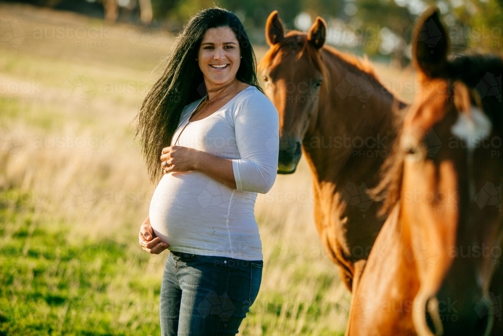Pregnant woman with her pet horses - Australian Stock Image