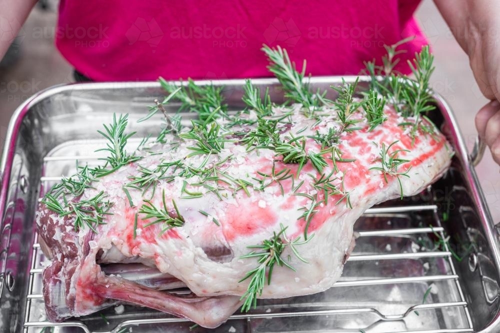 prepared lamb leg ready for roasting, with garlic, rosemary, salt and olive oil - Australian Stock Image