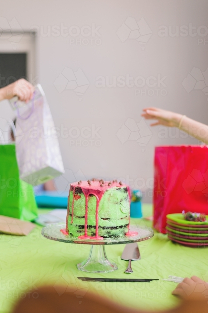 presents being handed out at a birthday party, focus on the cake - Australian Stock Image