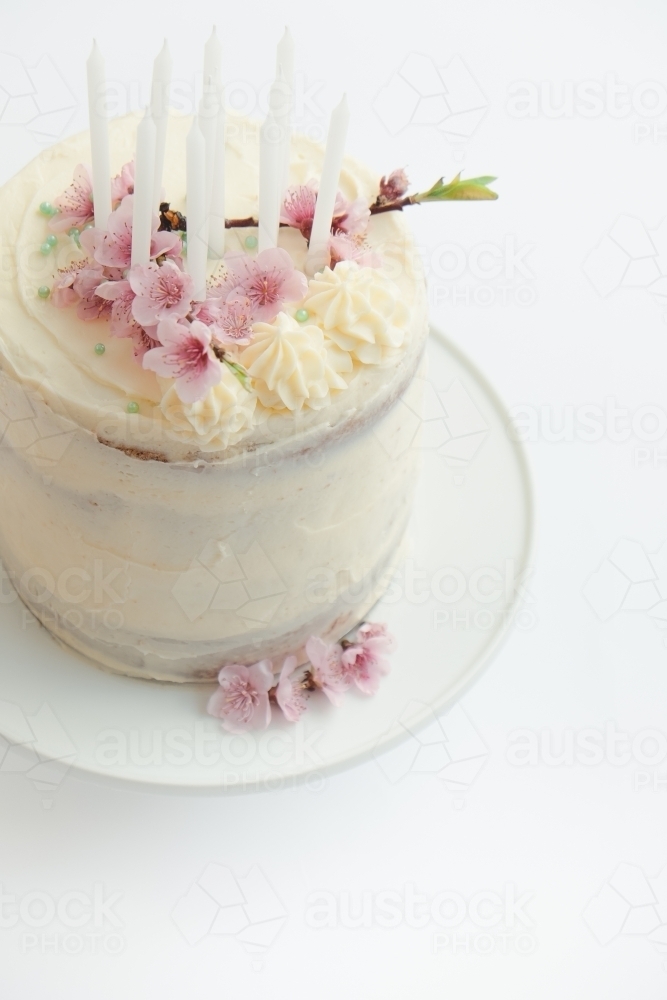 Pretty birthday cake with spring blossom and candles - Australian Stock Image