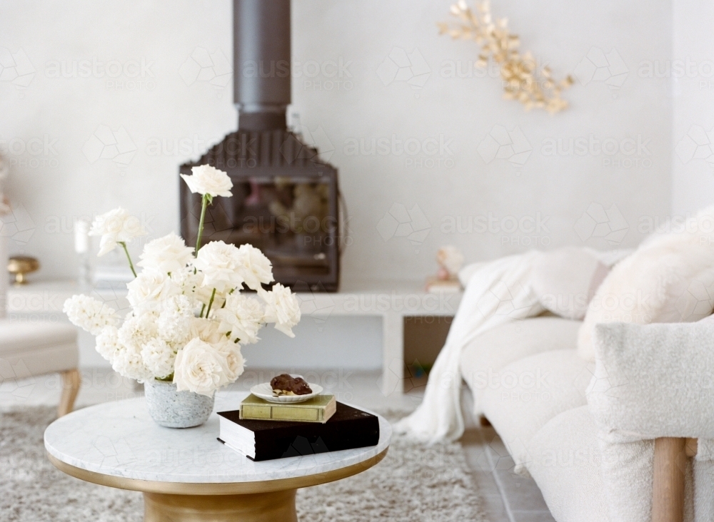 Pretty Bright Living Room with White Furnitures and Fire Place and White Roses - Australian Stock Image