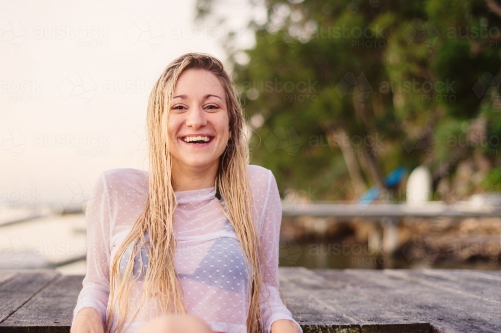 pretty model sitting on jetty - Australian Stock Image
