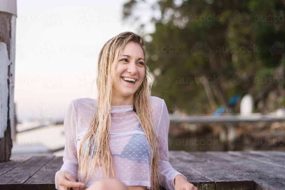 pretty model sitting on jetty - Australian Stock Image
