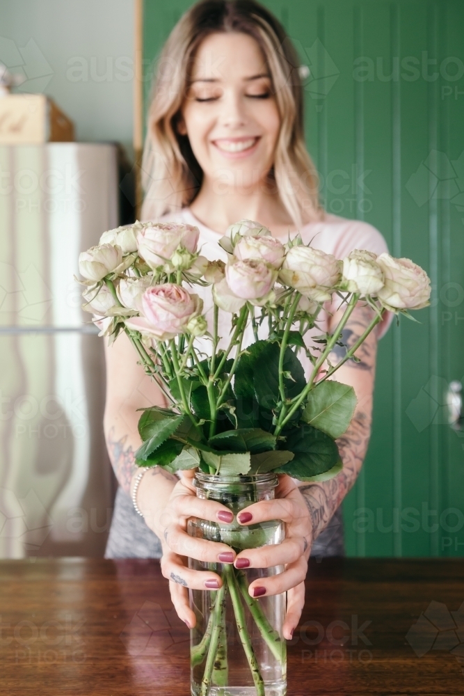Pretty pink vintage style rose being held to camera by a young woman - Australian Stock Image