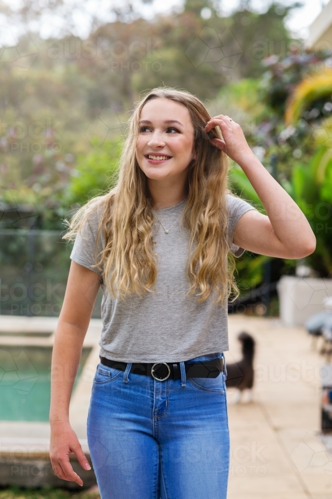 pretty teen with long hair, casual fashion jeans and a tee - Australian Stock Image