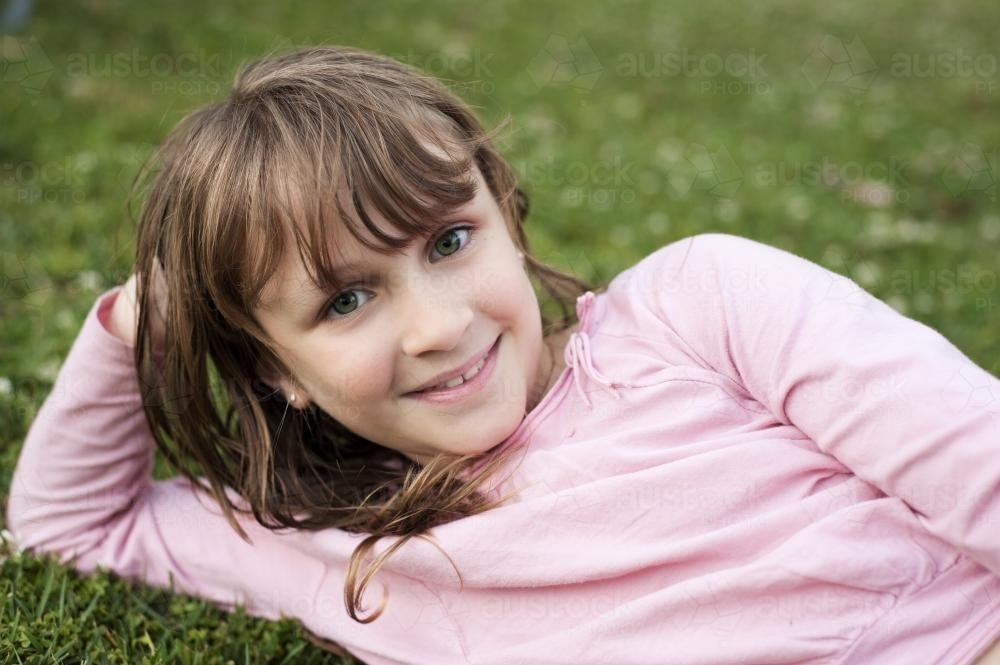 pretty tween girl resting in the grass - Australian Stock Image