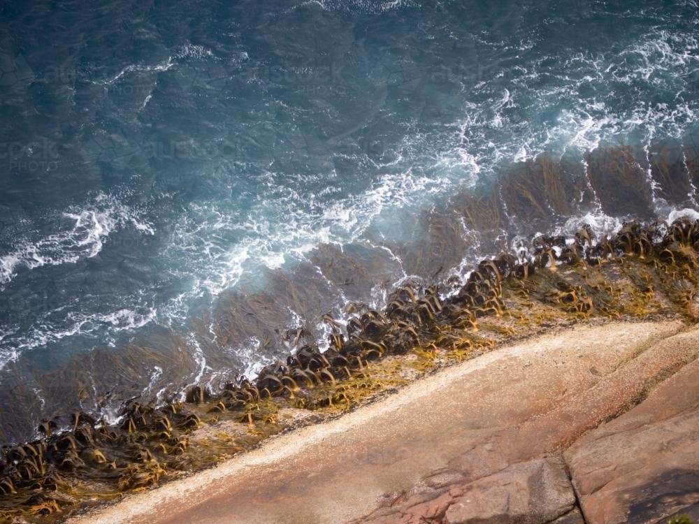Pretty wave pattern and seaweed viewed from a cliff top - Australian Stock Image