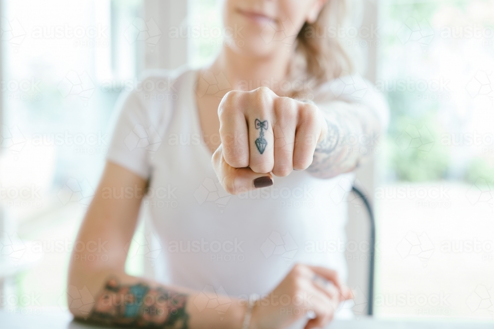Pretty young girl punching fist sending a message of power - Australian Stock Image