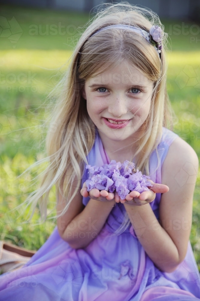 Pretty young girl with jacaranda flowers in her hands - Australian Stock Image