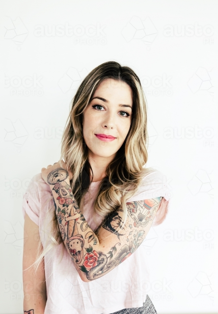 Pretty young woman showing off her colourful tattoo body art : Austockphoto Pretty young woman showing off her colourful tattoo body art - Australian Stock Image