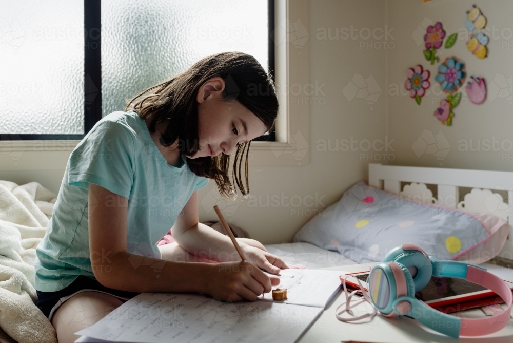 Image of Primary school girl student at home using tablet computer for ...