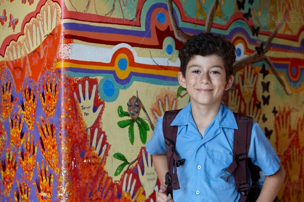 Primary school student at school, with wall mural behind - Australian Stock Image