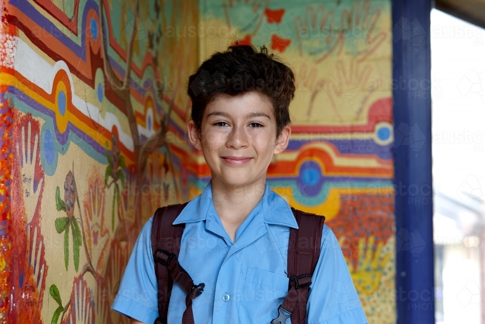 Primary school student at school, with wall mural behind - Australian Stock Image