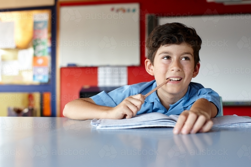 Primary school student in classroom doing homework - Australian Stock Image