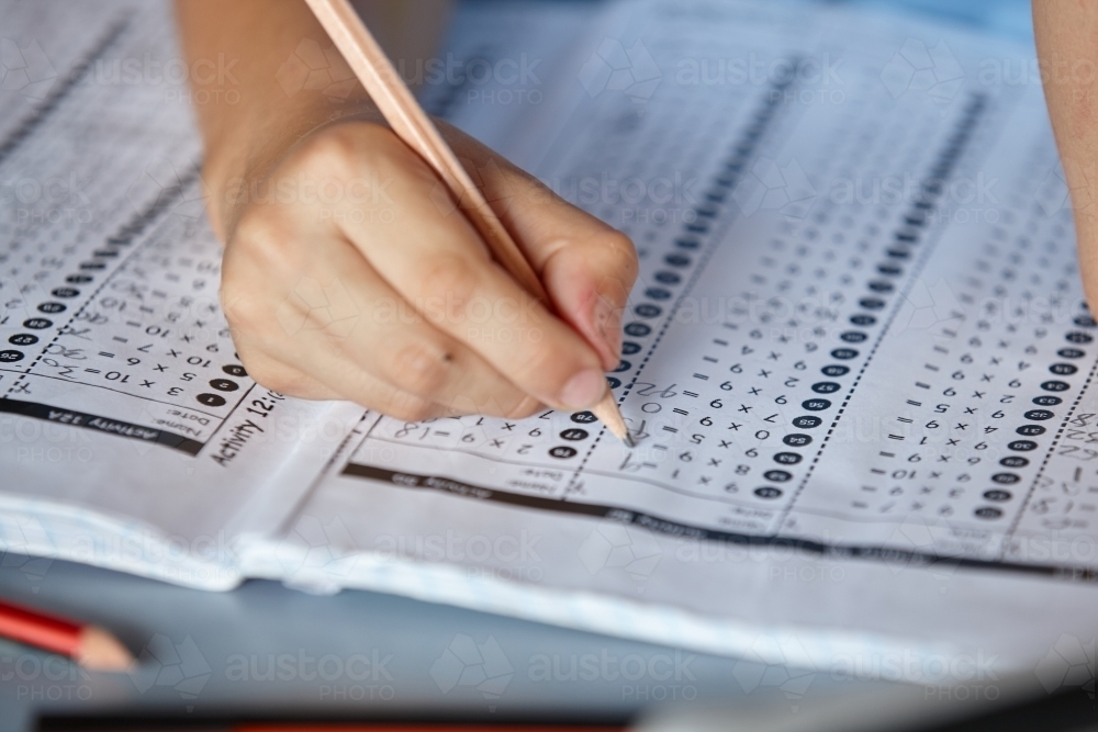 Primary school student in classroom working on homework - Australian Stock Image