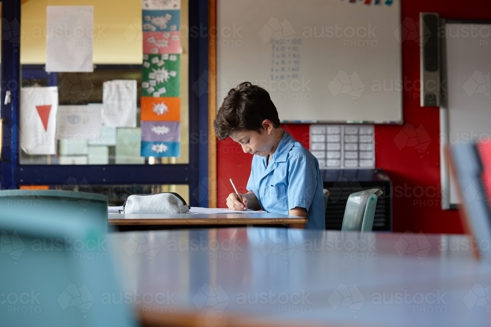 Image of Primary school student in classroom working on homework ...