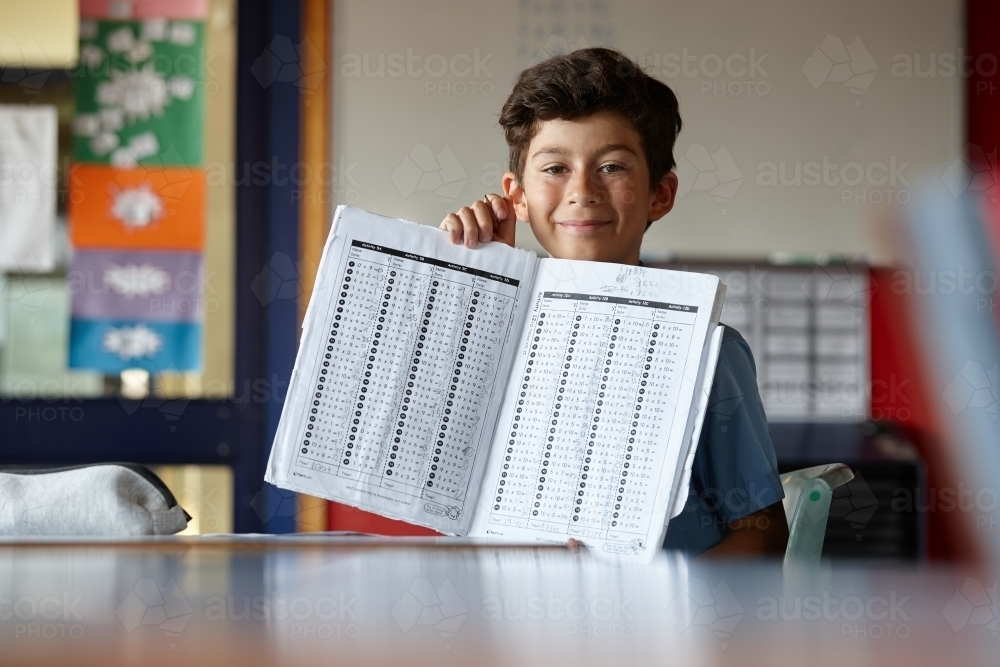 Primary school student in classroom working on homework - Australian Stock Image