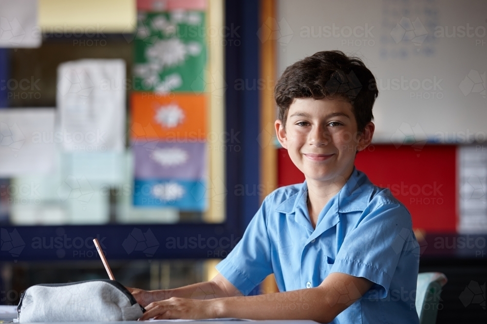 Primary school student in classroom working on homework - Australian Stock Image