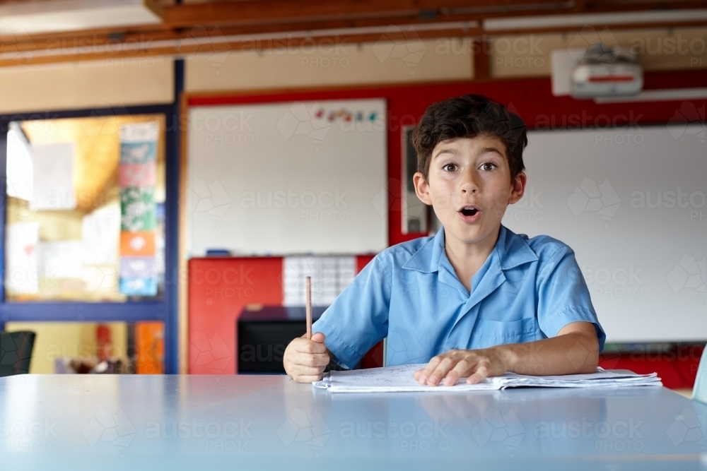 Primary school student in classroom working on homework - Australian Stock Image