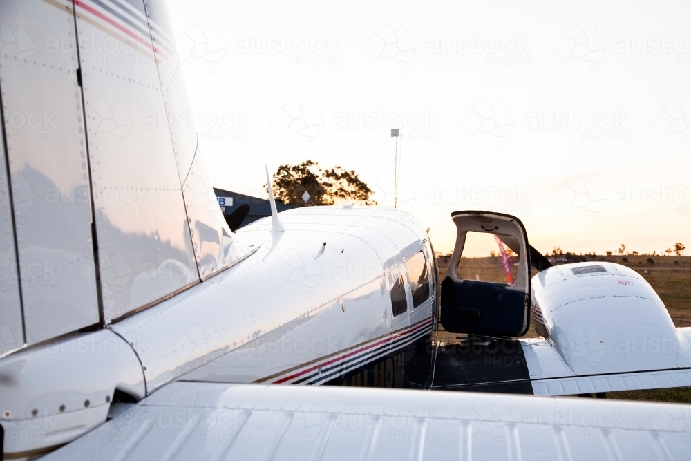 Private twin engine aeroplane on rural landing strip at dusk - Australian Stock Image