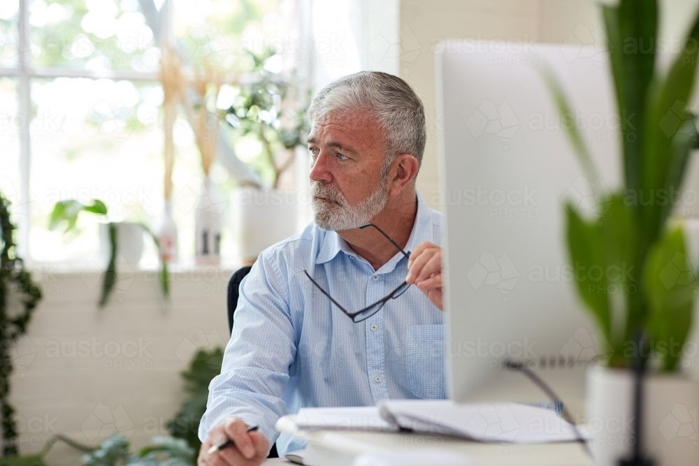 Professional business man sitting in an open plan office - Australian Stock Image