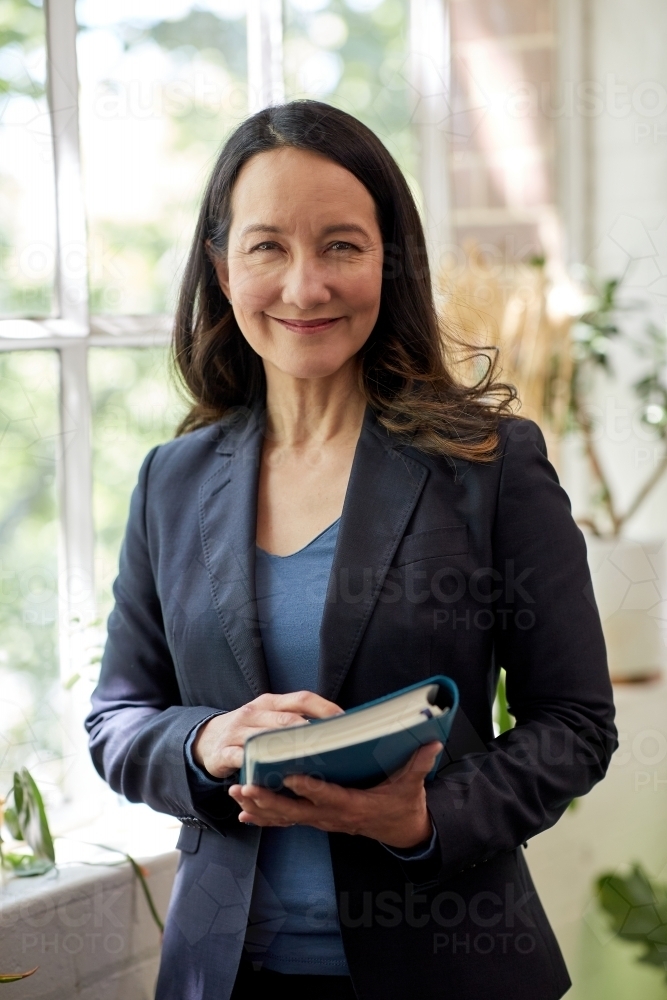 Professional business woman sitting at a computer in studio - Australian Stock Image