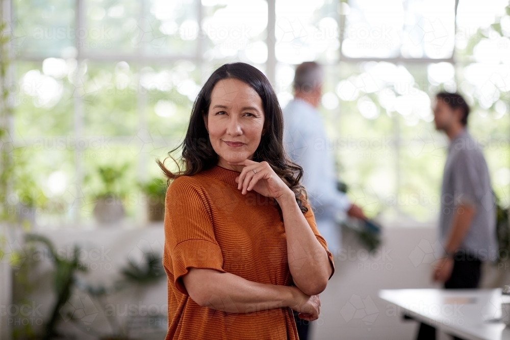 Professional business woman standing thinking in a studio office - Australian Stock Image