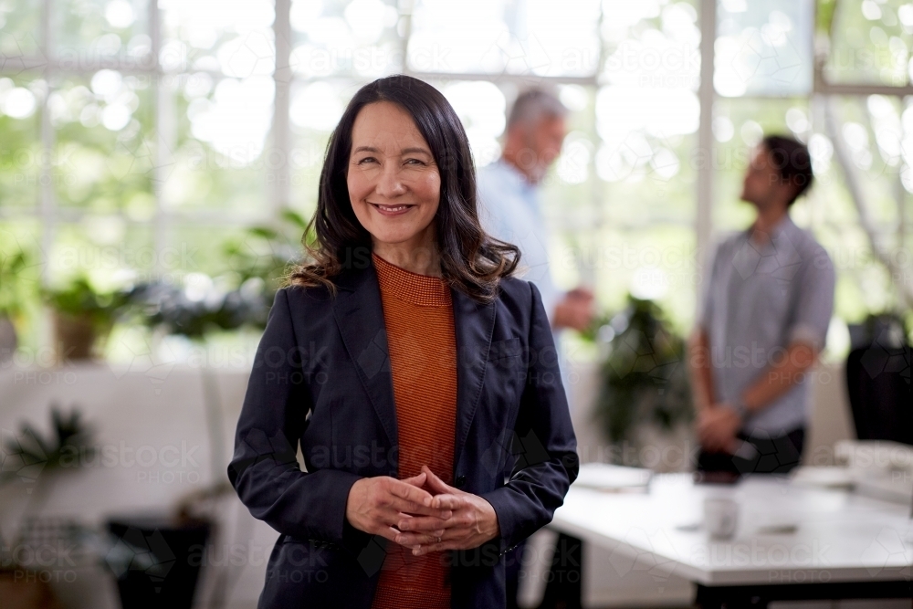 Professional business woman standing thinking in a studio office - Australian Stock Image