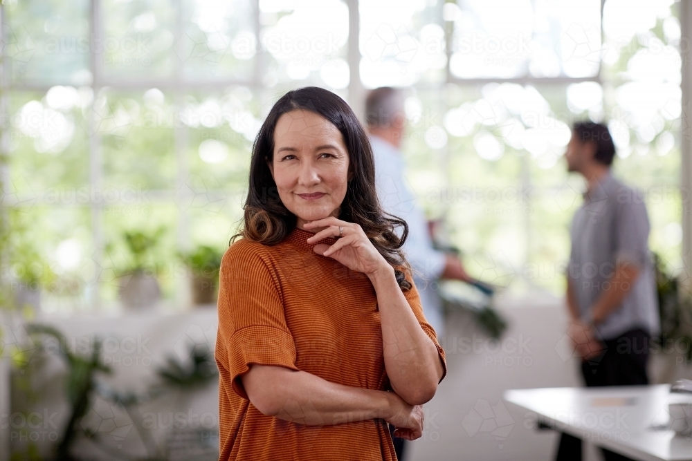 Professional business woman, standing thinking in an office studio - Australian Stock Image