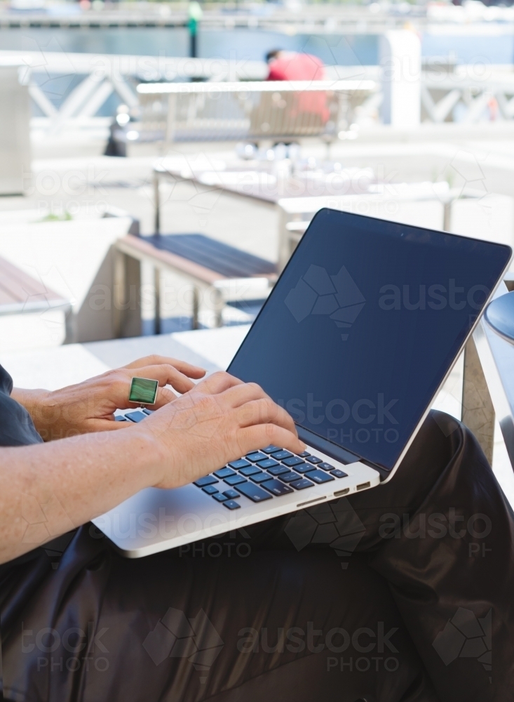 Professional woman working remotely on her laptop at an outdoor restaurant - Australian Stock Image