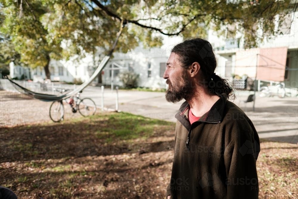 Profile of Man with Long Hair in his Backyard - Australian Stock Image