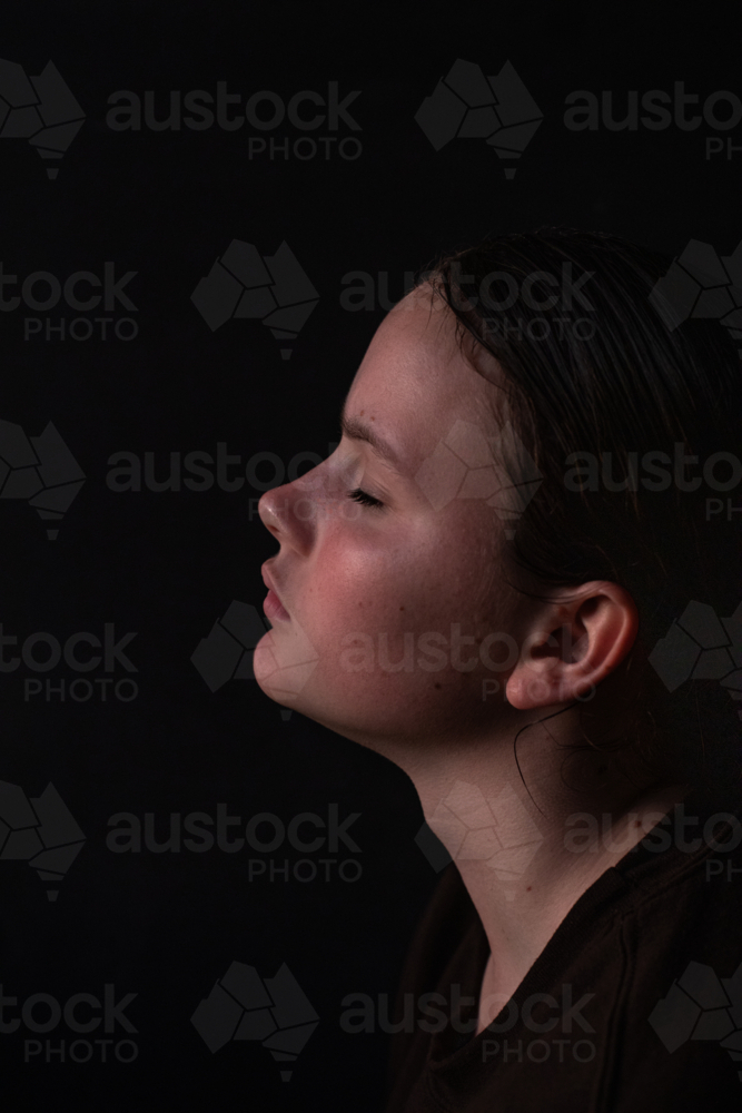 Image of Profile portrait of a young woman with eyes closed - Austockphoto
